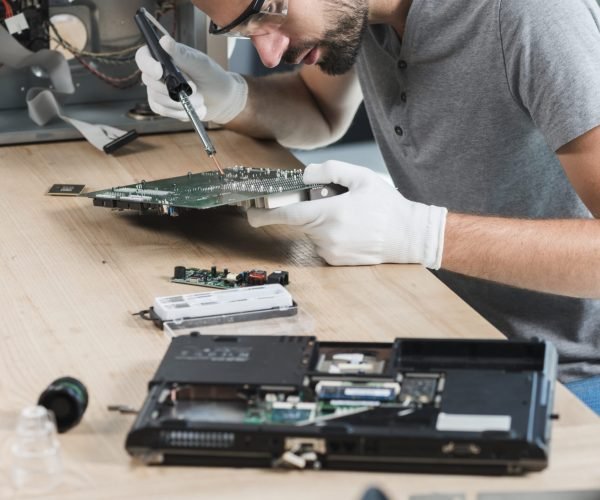 male-technician-repairing-computer-motherboard-wooden-desk male-technician-repairing-computer-motherboard-wooden-desk
